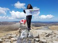 Liz Rose stands at the top of Mount Kosciuszko, in Australia in this undated handout photo. From Everest to Denali, a mountaineer from British Columbia has climbed to a record after spending more than two years scaling some of the tallest peaks on Earth.