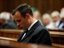 This file photo taken on July 6, 2016 shows Paralympian athlete Oscar Pistorius (L), accused of the murder of his girlfriend Reeva Steenkamp three years ago, looking on during the hearing in his murder trail at the High Court in Pretoria.