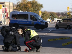 Police investigate at the scene of a fatal motor vehicle collision on Main Street near Sutherland Avenue in Winnipeg on Wed., Oct. 11, 2017. Const. Justin Holz, 34, was charged with impaired driving causing death after a pedestrian was struck and killed.