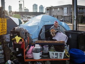 Tamara Ashley is pictured with her dog Gizmo outside of her tent on 135a Street in Surrey, British Columbia on December 17, 2017.