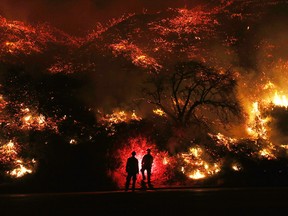 Firefighters monitor a section of the Thomas Fire along the 101 freeway on December 7, 2017 north of Ventura, California.