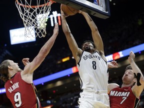 Brooklyn Nets' Spencer Dinwiddie (8) shoots between Miami Heat's Kelly Olynyk (9) and Goran Dragic (7) during the first half of an NBA basketball game Friday, Dec. 29, 2017, in Miami.