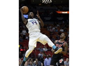 Charlotte Hornets' Michael Kidd-Gilchrist (14) passes over Miami Heat's Dion Waiters during the first half of an NBA basketball game, Friday, Dec. 1, 2017, in Miami.