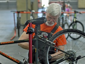 Adrian Pearce, shown checking a bike at the  annual Edmonton Bike Swap on May 9, 2015, is trying now to find his high school girlfriend.