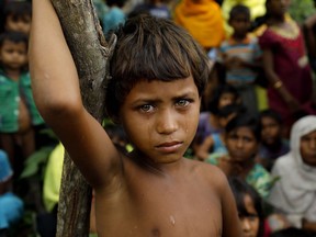 A Rohingya refugee looks next to newly arrived refugees who fled to Bangladesh from Myanmar in Ukhiya on September 6, 2017.