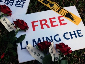 Roses are placed on a sign demanding the release of Taiwanese NGO worker Lee Ming-cheh during a protest in Taipei on November 28, 2017