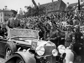 Undated photo taken from the year 1937 shows German Chancellor Adolf Hitler standing in a convertible Mercedes reviewing SA and SS troops and wellwishers somewhere in Germany.  A 1939 luxury Mercedes limousine used to carry Adolf Hitler around Germany will be auctioned in the U.S. state of Arizona next month — one of only four such models ever built.