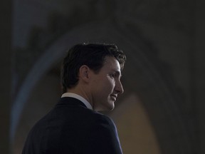 Prime Minister Justin Trudeau listens to a question from the media in the foyer of the House of Commons following the release of an ethics report in Ottawa on Wednesday Dec. 20, 2017.