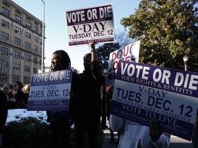 Supporters stand outside encouraging for people to vote after Democratic senatorial candidate Doug Jones spoke at a campaign rally Sunday, Dec. 10, 2017, in Birmingham, Ala.