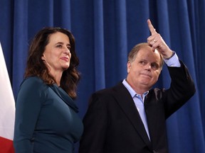 Democratic Sen.-elect Doug Jones waves to reporters as he and his wife Louise leave a news conference Wednesday, Dec. 13, 2017, in Birmingham, Ala. Weary national Republicans breathed a collective sigh of relief on Wednesday, a day after voters knocked out their own party's scandal-plagued candidate in deep-red Alabama.
