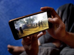 In this Dec. 23, 2017 photo, Mujibullah, 22, a Rohingya refugee watches a video, which he has shot in Myanmar before crossing over into Bangladesh, at Kutupalong refugee camp in Ukhiya, Bangladesh.  For many Rohingya living in refugee camps in Bangladesh, all that remains of their old lives in Myanmar are memories captured in photos and videos on their cellphones. Since August, more than 630,000 Rohingya Muslims have fled to Bangladesh to escape attacks by Myanmar security forces. Few refugees had the chance to grab many belongings when they fled, but most took their cellphones.