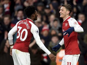 Arsenal's Mesut Ozil, right, celebrates scoring his side's first goal of the game with teammate Ainsley Maitland-Niles, during the English Premier League soccer match between Arsenal and Newcastle United, at the Emirates Stadium, in London, Saturday, Dec. 16, 2017.