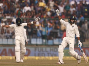 India's Murali Vijay, right, celebrates after scoring a century during the first day of their third test cricket match against Sri Lanka in New Delhi, India, Saturday, Dec. 2, 2017.