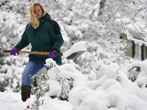 FILE - In this Saturday, Dec. 9, 2017 file photo, Laura Washington shovels her walk after a heavy snow, in Kennesaw, Ga. Thousands remained without electricity across the Deep South on Monday, Dec. 11, days after the storm snapped power lines across the region. Metro Atlanta got several inches of snow Friday and Saturday, while some areas farther north saw up to a foot of snowfall.