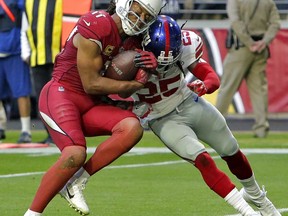 Arizona Cardinals wide receiver Larry Fitzgerald (11) scores a touchdown as New York Giants defensive back Brandon Dixon (25) defends during the first half of an NFL football game, Sunday, Dec. 24, 2017, in Glendale, Ariz.