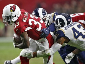 Arizona Cardinals running back Kerwynn Williams (33) is hit by Los Angeles Rams strong safety John Johnson (43) during the first half of an NFL football game, Sunday, Dec. 3, 2017, in Glendale, Ariz.