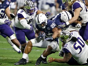 Penn State running back Saquon Barkley (26) is hit by Washington linebacker Benning Potoa'e (8) during the first half of the Fiesta Bowl NCAA college football game, Saturday, Dec. 30, 2017, in Glendale, Ariz.