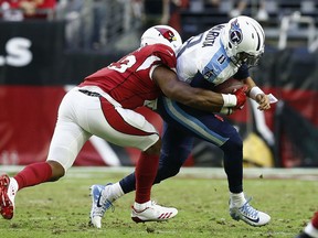 Arizona Cardinals inside linebacker Haason Reddick, left, brings down Tennessee Titans quarterback Marcus Mariota (8) during the second half of an NFL football game Sunday, Dec. 10, 2017, in Glendale, Ariz. The Cardinals defeated the Titans 12-7.