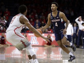 Connecticut guard Jalen Adams (4) drives on Arizona guard Parker Jackson-Cartwright during the first half of an NCAA college basketball game Thursday, Dec. 21, 2017, in Tucson, Ariz.