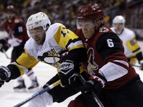 Arizona Coyotes defenseman Jakob Chychrun (6) and Pittsburgh Penguins right wing Bryan Rust battle for the puck in the first period during an NHL hockey game, Saturday, Dec. 16, 2017, in Glendale, Ariz.