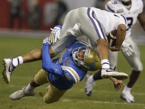 UCLA defensive back Nate Meadors (22) tackles Kansas State quarterback Alex Delton in the first half during an NCAA college football bowl game, Tuesday, Dec. 26, 2017, in Phoenix.