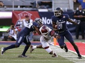 Utah State wide receiver Ron'quavion Tarver (1) avoids a tackle from New Mexico State linebacker Terrill Hanks (2) in the first half of the Arizona Bowl NCAA college football game Friday, Dec. 29, 2017, in Tucson, Ariz.
