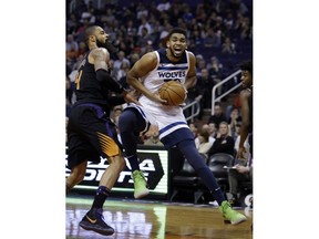 Minnesota Timberwolves center Karl-Anthony Towns (32) drives against Phoenix Suns center Tyson Chandler in the first quarter during an NBA basketball game, Saturday, Dec. 23, 2017, in Phoenix.