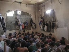 FILE - In this Tuesday, July 18, 2017 file photo, suspected Islamic State members sit inside a small room in a prison south of Mosul. Iraq said Saturday, Dec. 9, 2017 that its war on the Islamic State is over after more than three years of combat operations drove the extremists from all of the territory they once held. Prime Minister Haider al-Abadi announced Iraqi forces were in full control of the country's border with Syria.