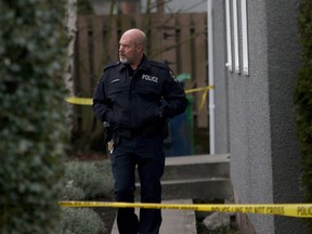 An Oak Bay officer leaves the apartment building where the bodies of sisters aged four and six were found by police on Boxing Day in the community of Oak Bay in Victoria, B.C., on Wednesday, December 27, 2017.