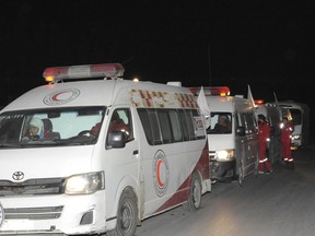 In this photo released by the Syrian official news agency SANA, members of the Syrian Arab Red Crescent gather near their ambulances during a human evacuation of sick and wounded people from the eastern Ghouta, near Damascus, Syria, Thursday, Dec. 28, 2017. The government recently tightened its siege of eastern Ghouta, home to some 400,000 people, leading to severe shortages of food, fuel and medicine as winter sets in.