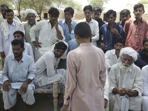 In this Aug. 18, 2017, a Pakistani boy, center, who said he was raped by a religious cleric, stands before villagers in Vehari, Pakistan. Naeema Kishwar, a federal lawmaker, said that laws exist to tackle sexual abuse of minors, not only in madrassas but in public schools, at home and among the army of child workers who are employed in homes as domestic workers and in factories.