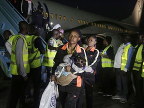 FILE - In this Dec. 5, 2017, file photo, Nigerian returnees from Libya disembark from a plane upon arrival at the Murtala Muhammed International Airport in Lagos, Nigeria. An emergency effort has begun to repatriate thousands of migrants stranded in camps across Libya, but now the returnees are posing a challenge. Back home in countries across Africa, they face the same conditions that led them to leave: high unemployment, often weak economies, an increasingly harsh climate. Governments are under pressure to give their citizens a reason to stay.