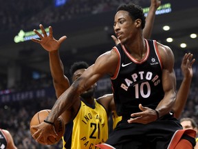 Raptors guard DeMar DeRozan moves the ball around the Indiana Pacers' Thaddeus Young (21) during first half NBA action in Toronto on Friday night.