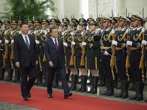 South Korean President Moon Jae-in, center right, and Chinese President Xi Jinping review the Chinese honor guard during a welcoming ceremony at the Great Hall of the People in Beijing, Thursday, Dec. 14, 2017.