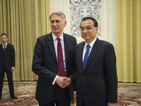 China's Premier Li Keqiang, right, meets Britain's Chancellor of the Exchequer Philip Hammond at the Great Hall of the People in Beijing, Friday, Dec. 15, 2017.