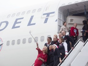 Delta Air Lines crew members take a selfie photograph while disembarking from a Boeing 747 after landing at Paine Field in Everett, Washington, on Dec. 18, 2017.