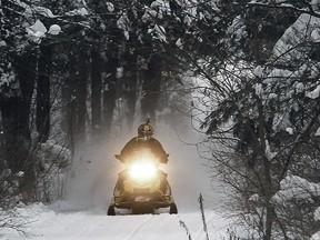 FILE - In this Dec. 31, 2012 file photo, a snowmobile travels a newly-groomed trail in East Montpelier, Vt. With plenty of fresh snow covering much of northern New England, the 2017 winter snowmobile season is off to a good start.
