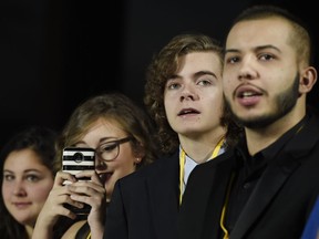 In this Dec. 9, 2017 photo, Oliva Sava, from left, Shannon McNabb, Tyler Woodward and Chris Alegria peer down the red carpet from their spot at the premiere of the film "Star Wars: The Last Jedi" in Los Angeles.  The teens were among seven teens with life-threatening medical conditions who were among the special guests at the premiere as part of the Make-A-Wish Foundation.