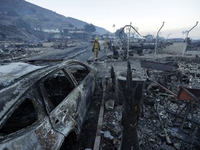 Fire crews search for hot spots among destroyed homes in the Rancho Monserate Country Club community Friday, Dec. 8, 2017, in Fallbrook, Calif. The wind-swept blazes have forced tens of thousands of evacuations and destroyed dozens of homes in Southern California.