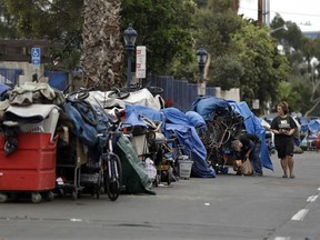 In this Sept. 19, 2017 photo, trash from homeless encampments lines a street in San Diego. In a place that bills itself as "America's Finest City," renowned for its sunny weather, surfing and fish tacos, spiraling real estate values have contributed to spiraling homelessness in San Diego. Most alarmingly, the explosive growth in the number of people living outdoors has contributed to a hepatitis A epidemic.