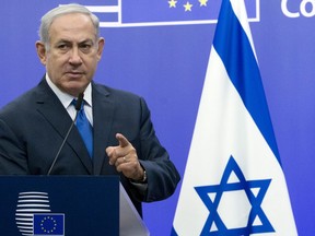 FILE - In this Monday, Dec. 11, 2017 file photo, Israeli Prime Minister Benjamin Netanyahu addresses a media conference with European Union High Representative Federica Mogherini at the EU Council building in Brussels. With the prime minister facing a slew of corruption allegations, the peace process at a standstill and the government moving to stifle critics, it is no secret that Israel is a deeply divided nation. But a new survey released Tuesday shows just how divided the country has become.