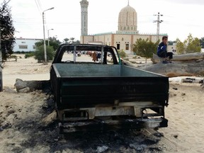 FILE - Im this Nov. 25, 2017 file photo, a burned truck is seen outside Al-Rawda Mosque in Bir al-Abd northern Sinai, Egypt a day after attackers killed hundreds of worshippers. The Egypt mosque massacre could point to the rise of an ultra-extremist faction that is so radical in its readiness to kill fellow Muslims that it has caused rifts within the Islamic State group _ already notorious for its atrocities.