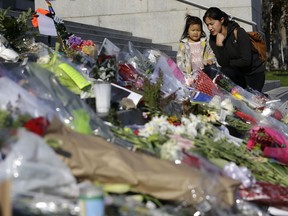 Diana Wang talks with her daughter Leah after leaving flowers for Mayor Ed Lee on the steps of City Hall in San Francisco, Wednesday, Dec. 13, 2017. Lee died Tuesday at 65 after collapsing while grocery shopping.