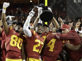 Southern California coach Clay Helton, right, celebrates with players after a 31-28 win over Stanford in the Pac-12 Conference championship NCAA college football game in Santa Clara, Calif., Friday, Dec. 1, 2017.