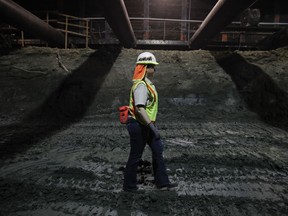 In this Aug. 15, 2017 photo, paleontologist Ashley Leger navigates through the construction site of the Metro Purple Line extension in Los Angeles. Earth-movers are diverted, and Leger gets on her hands and knees and gently brushes the dirt from a spot pointed out by a member of her team. Her heart beats faster because there's a chance she'll uncover what she calls "the big find."