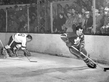 Tim Horton (right) skates away from Detroit Red Wings forward Tony Leswick on March 5, 1954.