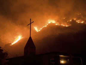 Flames from a wildfire advance down a hillside near the Springs of Life Church in Casitas Springs, Calif., on Tuesday, Dec. 5, 2017.  Wind-driven fires tore through California communities Tuesday for the second time in two months, leaving hundreds of homes feared lost and uprooting tens of thousands of people.