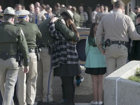 Rosanna Camilleri, right, the wife of late California Highway Patrol Officer Andrew Camilleri Sr, hugs CHP officer Jonathan Velazquez following a bell ringing ceremony held at the highway patrol academy Wednesday, Dec. 27, 2017, in West Sacramento, Calif. Camilleri Sr, was sitting into the passenger seat of the patrol vehicle operated by Velazquez, that was parked on the shoulder of Interstate 880 Christmas Eve night when their vehicle was struck by vehicle that drifted off the highway. Velazquez suffered miner injuries, was treated and released from a nearby medical center. The driver of the other vehicle, who was believed to be under influence of marijuana and alcohol at the time of the accident, remains in the hospital with serious injuries. Officials fear such drug-impaired-accidents will increase after California legalizes the sale of recreational marijuana Jan. 1, 2018.