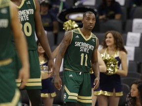 In this photo taken Tuesday, Nov. 21, 2017, Sacramento State guard Kevin Hicks, right, is seen during a timeout in an NCAA college basketball game against UC Davis in Sacramento, Calif. Hicks broke down in his first trip back to the 9th Ward of New Orleans since Hurricane Katrina uprooted his family. The bones are what hit Hicks. Not the house that was destroyed, not the devastation still apparent three years later, not the clothes wadded up in the corner of what was once his bedroom. No, the bones of the family dog scattered in the yard are what did it.