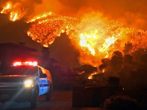 In this photo provided by the Santa Barbara County Fire Department, fire burns canyons and ridges above Bella Vista Drive near Romero Canyon as the fight to contain a wildfire continues in Montecito, Calif., Tuesday, Dec. 12, 2017. The fifth-largest wildfire in California history expanded Tuesday, ripping through dry brush atop a coastal ridge while crews struggled to keep flames from roaring down into neighborhoods amid fears of renewed winds.